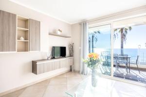 a living room with a television and a view of the ocean at LE MIDI 8 by ESTATES CANNES in Cannes