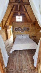 ein Schlafzimmer mit einem Bett in einer Holzhütte in der Unterkunft Los Nevados Ecolodge in Gigante