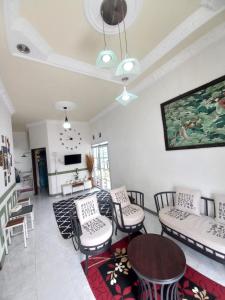 een woonkamer met een bank, stoelen en een tafel bij Homestay Berkah Syariah Bukittinggi in Bukittinggi