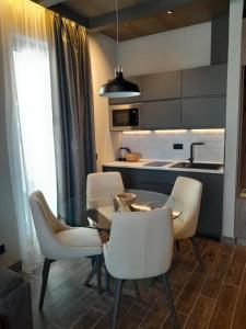 a kitchen with a glass table and white chairs at Stefany in Kopaonik +11 photos