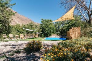 ein Drachen fliegt über einen Garten mit Stühlen und einem Pool in der Unterkunft Cabaña de montaña (jacuzzi exterior) in San Alfonso