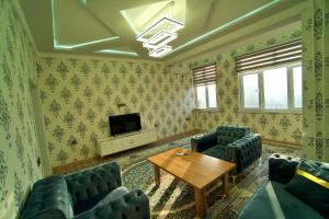 een woonkamer met blauwe banken en een houten tafel bij Royal apartment 2 in Doesjanbe