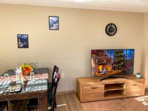 a dining room with a table and a television at IZ VIEW Apartment in Bansko