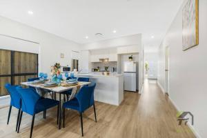 uma cozinha e sala de jantar com uma mesa e cadeiras azuis em Vivid House for your wonderful trip em Vineyard