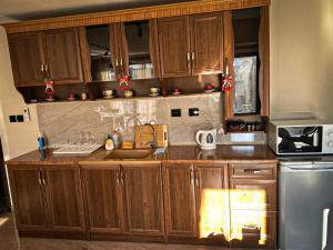 a kitchen with wooden cabinets and a stainless steel refrigerator at IZ VIEW Apartment in Bansko