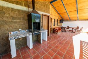 an outdoor kitchen with a fireplace on a brick wall at PANWEWE III in San Antonio de las Alzanas