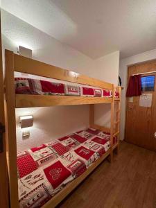 - une chambre avec 2 lits superposés et une porte dans l'établissement Appartement Courchevel les brigues, à Courchevel