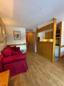 un salon avec un canapé rouge et des lits superposés dans l'établissement Appartement Courchevel les brigues, à Courchevel