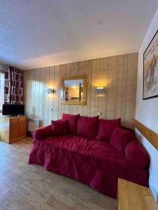 - un salon avec un grand canapé rouge dans l'établissement Appartement Courchevel les brigues, à Courchevel