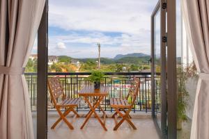 a balcony with a table and chairs and a view at LaMay Homestay in Da Lat