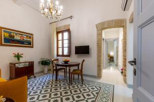 sala de estar con mesa, sillas y lámpara de araña en MCH-Marina Charming House, en Cagliari