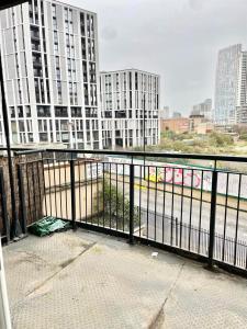 a balcony with a view of a city with tall buildings at Modern Apartment in Stratford in London