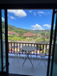a table and chairs on a balcony with a view at Petunya Phuket Guest House in Ban Huai Luk (1)