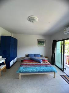 a bedroom with a bed and a blue cabinet at Petunya Phuket Guest House in Ban Huai Luk (1) +8 photos