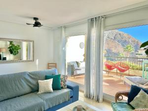 sala de estar con sofá azul y puerta corredera de cristal en Can Luc Altea, en Altea