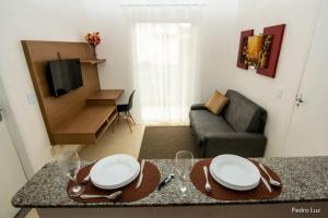 Apart Sol Nascente في إيتاتيايا: غرفة معيشة مع طاولة وأريكة