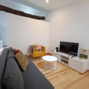 a living room with a couch and a tv at Tomarhousing - Style in Tomar