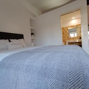 una camera da letto con un grande letto e un copriletto bianco di Tomarhousing - Style a Tomar