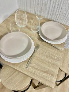 uma mesa com pratos e copos de vinho em Le Nid Douillet CENTRE VILLE em Decize