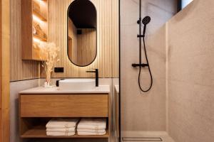 a bathroom with a sink and a shower at Stylchyn Park Lakefront Lodges - Czorsztyn Exclusive with SPA in Kluszkowce