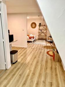 uma sala de estar com pisos em madeira e uma escadaria em Le Nid Douillet CENTRE VILLE em Decize