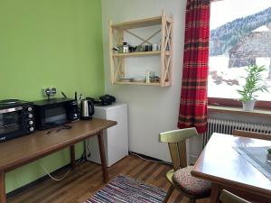 a room with a table with a microwave and a window at Urlaub am Fieglerberg 