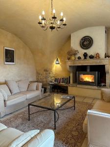 a living room with a couch and a fireplace at Gîte Le Mas du Colombeyras in Espeluche