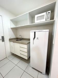 a small kitchen with a refrigerator and a microwave at V1318 Lindo flat aconchegante em andar alto in Brasilia