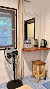 un ventilador en una habitación con una mesa y un espejo en Ko Phangan Haad Yao Beach Hotel, en Haad Tian