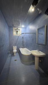La salle de bains est pourvue d'une baignoire, d'un lavabo et de toilettes. dans l'établissement نماء الجود للشقق المفروشة ( المستراح ), à Médine
