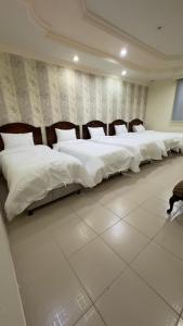 - une rangée de lits blancs dans une chambre dans l'établissement نماء الجود للشقق المفروشة ( المستراح ), à Médine