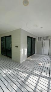 an empty room with white walls and glass doors at Ko Phangan Haad Yao Beach Hotel in Haad Tian