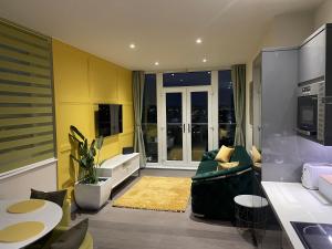 un soggiorno con pareti gialle e divano verde di Dutch Quarter a Colchester
