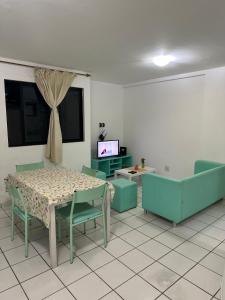 een kamer met een tafel en stoelen en een televisie bij APARTs na Litorânea Ferreira Hospedagens in São Luís