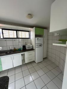 a kitchen with white cabinets and a white refrigerator at Apês Completos na Litorânea l Cozinha e Conforto l Ferreira Hospedagens in São Luís