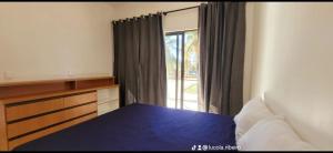 a bedroom with a blue bed and a window at FLECHEIRAS ATLANTICO in Trairi