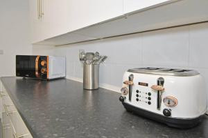 encimera de cocina con tostadora y tostadora en Ernest House - By Sigma Stays, en Crewe