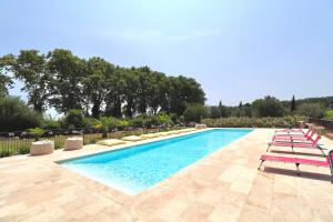 een groot zwembad met ligstoelen en een resort bij Chambres d'hôtes avec Jacuzzi et Piscine au Mas de Cadoule in Saint-Just