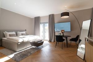 a bedroom with a bed and a table with chairs at Hotel DRAŠ in Maribor