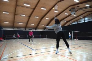 een vrouw die een tennisbal slaat met een racket bij Hotel DRAŠ in Maribor