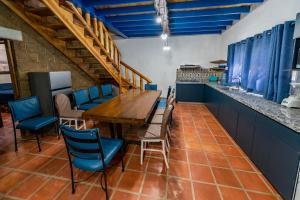 a dining room with a wooden table and blue chairs at TAMBO IV in San Antonio de las Alzanas