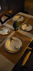 una mesa con placas blancas y una piña en ella en PerlaMarina, en Trapani