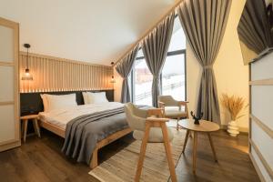 a bedroom with a bed and a large window at Black & White Villas by Fomich Hotels Group in Bukovel