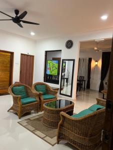 a living room with chairs and a ceiling fan at JAR NON Villa in Pantai Kok