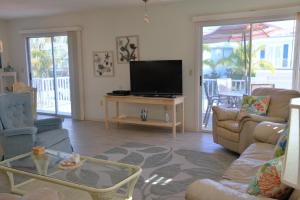 een woonkamer met een tv en een bank en een tafel bij Starfish Beach in Anna Maria