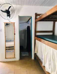 a room with a bunk bed and a fan at Hostel Itaparica Casa in Itaparica +19 photos