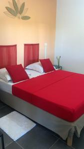 two beds with red covers in a room at Bas de Villa FloriRose in Rivière-Salée