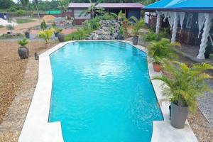 una piscina de agua azul en un patio en Eco Resort, en Carrefour de Mana
