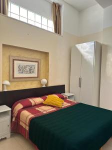 a bedroom with a large bed with a green blanket at b&b il villino in Matera