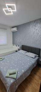um quarto com uma cama com duas toalhas verdes em Apartman TEJA DELUXE em Vrnjačka Banja